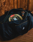 Waxed Duffel bag inside a golf clubhouse locker room – A premium duffel bag placed in a classic golf clubhouse locker room, highlighting its refined design and craftsmanship, with wooden lockers in the background, evoking a sense of tradition and elegance.