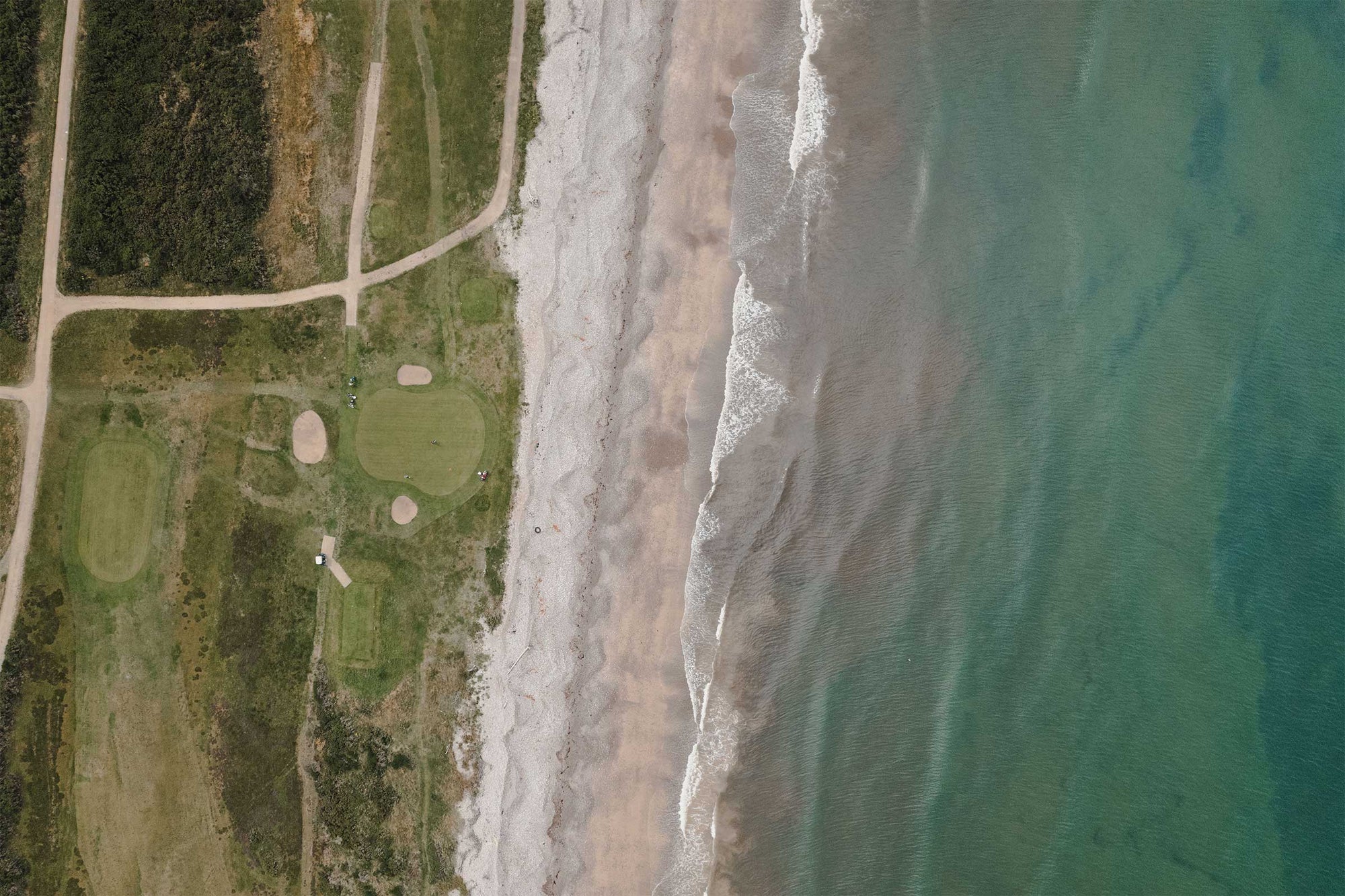 
Overhead view of Spey Bay golf course near the coastline – A stunning aerial shot showcasing the Spey Bay golf course, with the fairways stretching towards the coastline, highlighting the course’s seamless integration with the natural landscape and the beautiful contrast between the green grass and the blue sea.